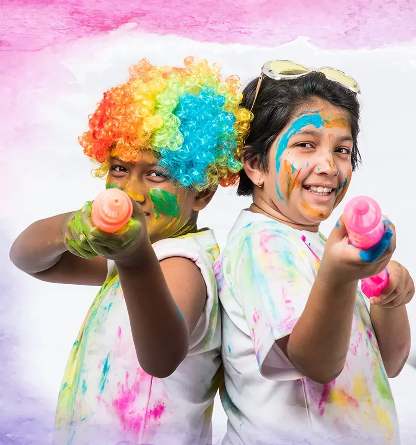 Children celebrating Holi together, covered in bright colours