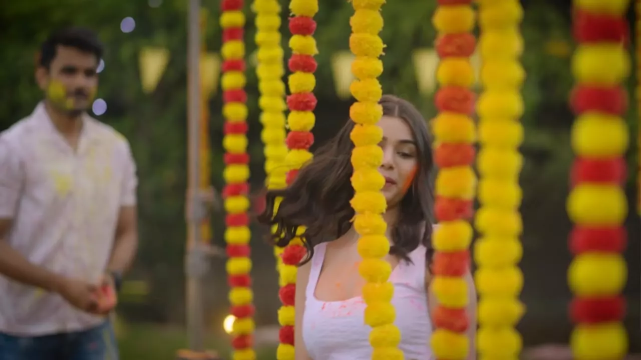 Holi being played under marigold garlands, colour on faces and clothes