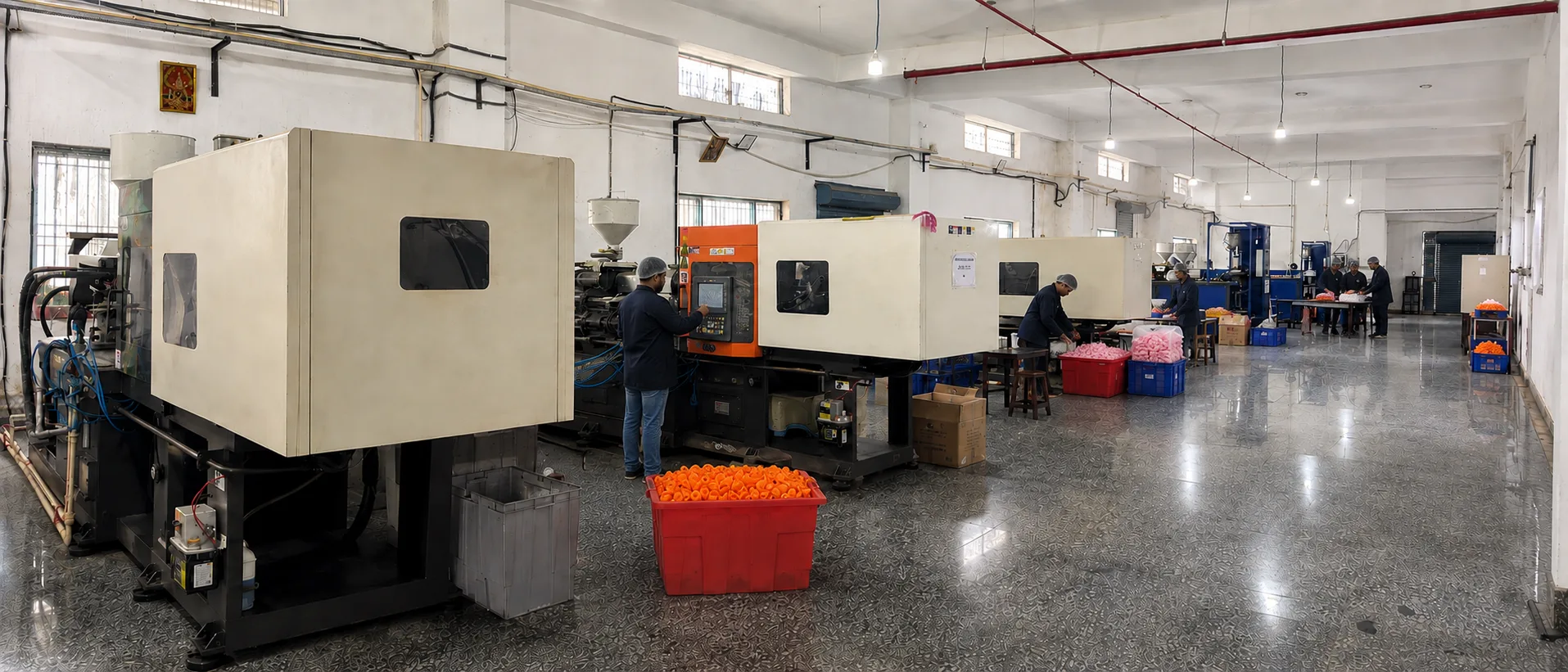 Injection moulding machines running at the Faridabad works, operators at the controls